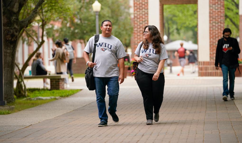 Two student veterans walking and talking on campus